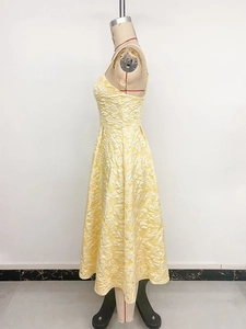 Close-up of yellow sleeveless A-line dress featuring rich jacquard textured fabric details