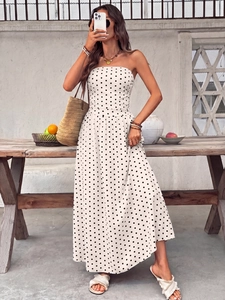 Detail of white strapless polka dot maxi dress with elastic high waist and flowy skirt