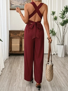 Detailed back view of burgundy jumpsuit with cross straps and elegant bow tie design