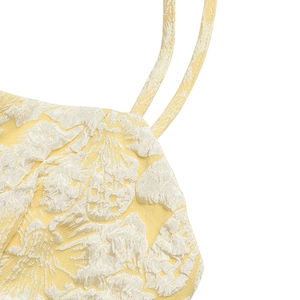 Detail of elegant yellow floral jacquard fabric with thin spaghetti straps for summer dress
