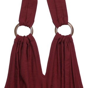 Detail view of burgundy jumpsuit showing V-neckline with resin rings and pleated fabric