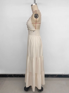 Détail d'une robe longue dos nu avec bordures en coquillages et franges de perles