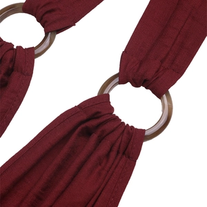 Detail of burgundy jumpsuit featuring a textured fabric and amber resin O-ring connector