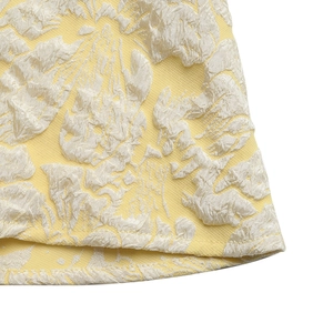 Close-up of elegant yellow floral jacquard fabric and high-quality hem stitching details