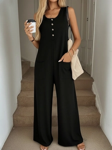 Detail view of black waffle texture jumpsuit with front metal buttons and side pockets