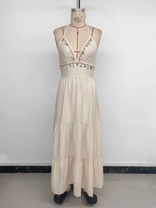 Détail de robe maxi dos nu à col en V avec glands en coquillage et jupe à plusieurs niveaux