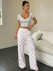 Dettaglio del top a costine con pizzo bianco e pantaloni larghi a cuori