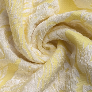 Detailed macro shot of yellow jacquard fabric featuring elegant floral patterns