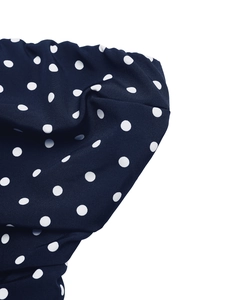 Macro shot of navy blue polka dot fabric texture for elegant summer strapless dress
