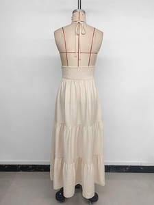 Détail de la robe longue dos nu à volants avec taille smockée de couleur beige