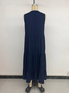 Détail d'une robe longue bleu marine à volants avec dentelle blanche au décolleté