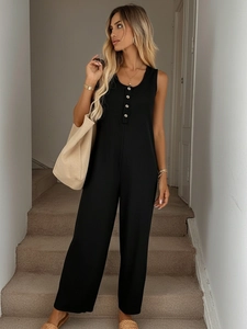 Detailed close-up of vertical ribbed knit texture and silver buttons on black jumpsuit