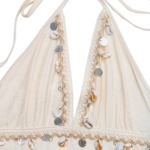 Détail d'un haut dos nu bohème avec bordure en coquillages et paillettes argent