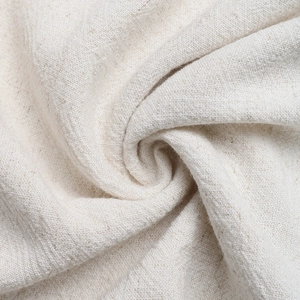 Dettaglio del tessuto in cotone e lino bianco crema con trama naturale e drappeggio