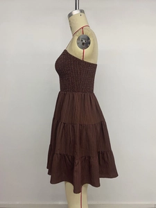 Detail of smocked elastic bodice and tiered skirt layers on a brown summer dress