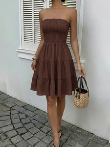 Detailed view of the dark brown smocked bodice and layered ruffle hem of this summer dress