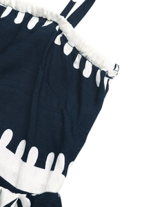 Detailed view of dark blue dress fabric with white abstract patterns and elastic smocked neckline