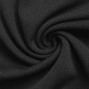 Macro shot of black honeycomb knit fabric texture showing high elasticity and soft weave