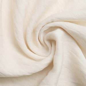 Gros plan sur le tissu plissé vertical crème avec une texture douce et élégante