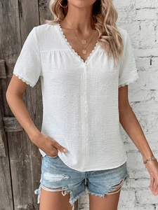 Close-up of elegant V-neckline with delicate lace trim on white summer shirt