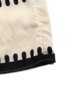 Detailaufnahme des Kleidsaums mit schwarzer Wellenspitze und Baumwoll-Leinen-Textur
