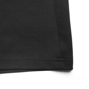 Macro view of black waffle weave fabric texture and neat stitching on wide leg jumpsuit