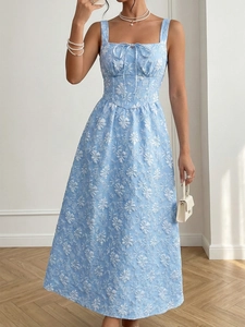 Detail of sky blue midi dress featuring intricate white floral jacquard and bow neckline