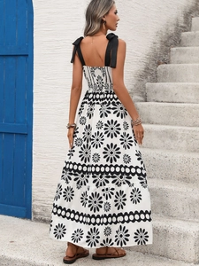 Detail of bohemian floral maxi dress with black daisy print and silk satin shoulder bows