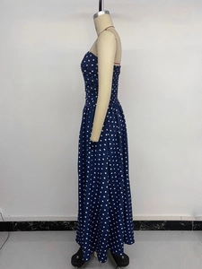 Detailed view of navy blue polka dot maxi dress featuring smocked waist and flared hem