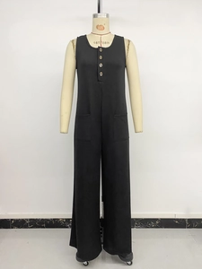 Detail view of black sleeveless wide-leg jumpsuit featuring wooden decorative buttons