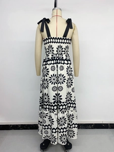 Detail of black daisy print on white maxi dress with adjustable ribbon shoulder straps