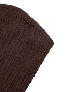Detailed macro view of dark brown smocked bubble fabric on the summer strapless dress