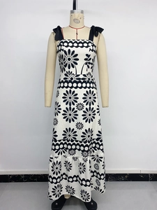 Detail of sunflower print maxi dress with black ribbon bow shoulder straps and ruffled hem