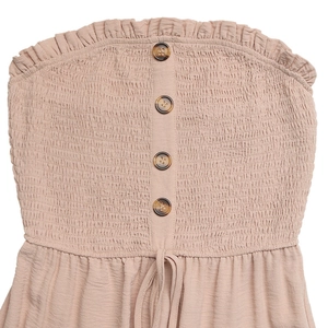 Close-up of pink smocked jumpsuit bodice with wooden buttons and ruffled edges