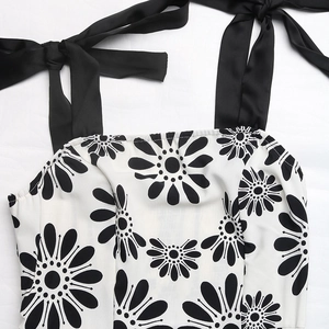 Detail of adjustable black silk tie straps and white daisy floral print on the dress