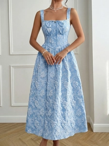 Macro detail of the light blue floral jacquard texture and bow tie on the dress
