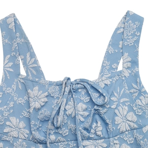 Detail of square neckline with blue jacquard floral fabric and bow tie decoration