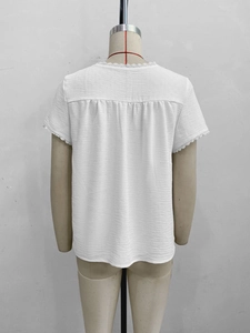 Detail view of white lace trim on sleeve and seersucker textured back of summer top