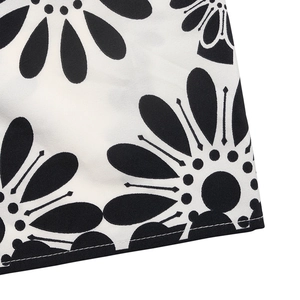 Macro detail of the black and white floral print and stitched hem on the summer dress