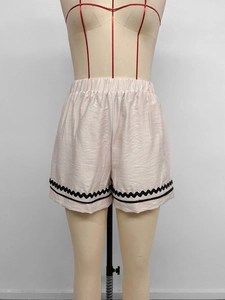 Détail du short d'été à taille haute élastique avec finitions de bordure ondulée noire
