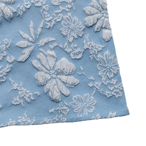 Detailed close-up of light blue floral jacquard fabric texture and stitching quality