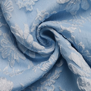 Close-up of light blue jacquard fabric with floral relief texture and silk-like luster