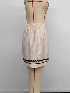 Détail du short rose clair à taille haute avec bordure en dentelle noire ondulée