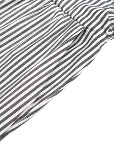 Detailed close-up of vertical black and white stripes on a textured fabric jumpsuit