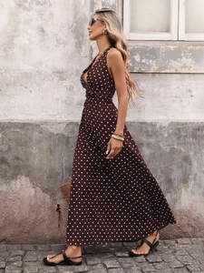 Detail of deep V-neck halter dress with white polka dots on brown fabric