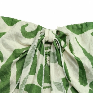 Detailed macro view of green and white floral print cotton-linen fabric with tied front design