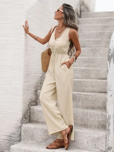 Close-up of cream sleeveless jumpsuit featuring V-neck crochet trim and texture