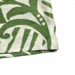 Macro detail of breathable cotton-linen fabric with green leaf print and neat stitching