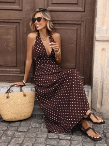 Detail of a brown polka dot halter maxi dress with deep V-neck and open back for summer