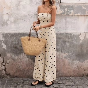 Détail d'une combinaison bustier à pois avec un sac en paille assorti dans une rue rustique